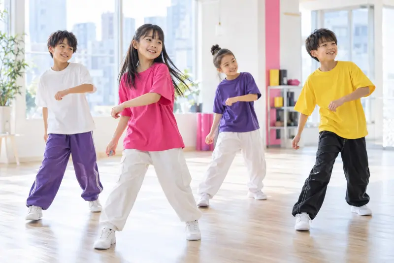 カラフルな服でダンスのステップを楽しむ子どもたち